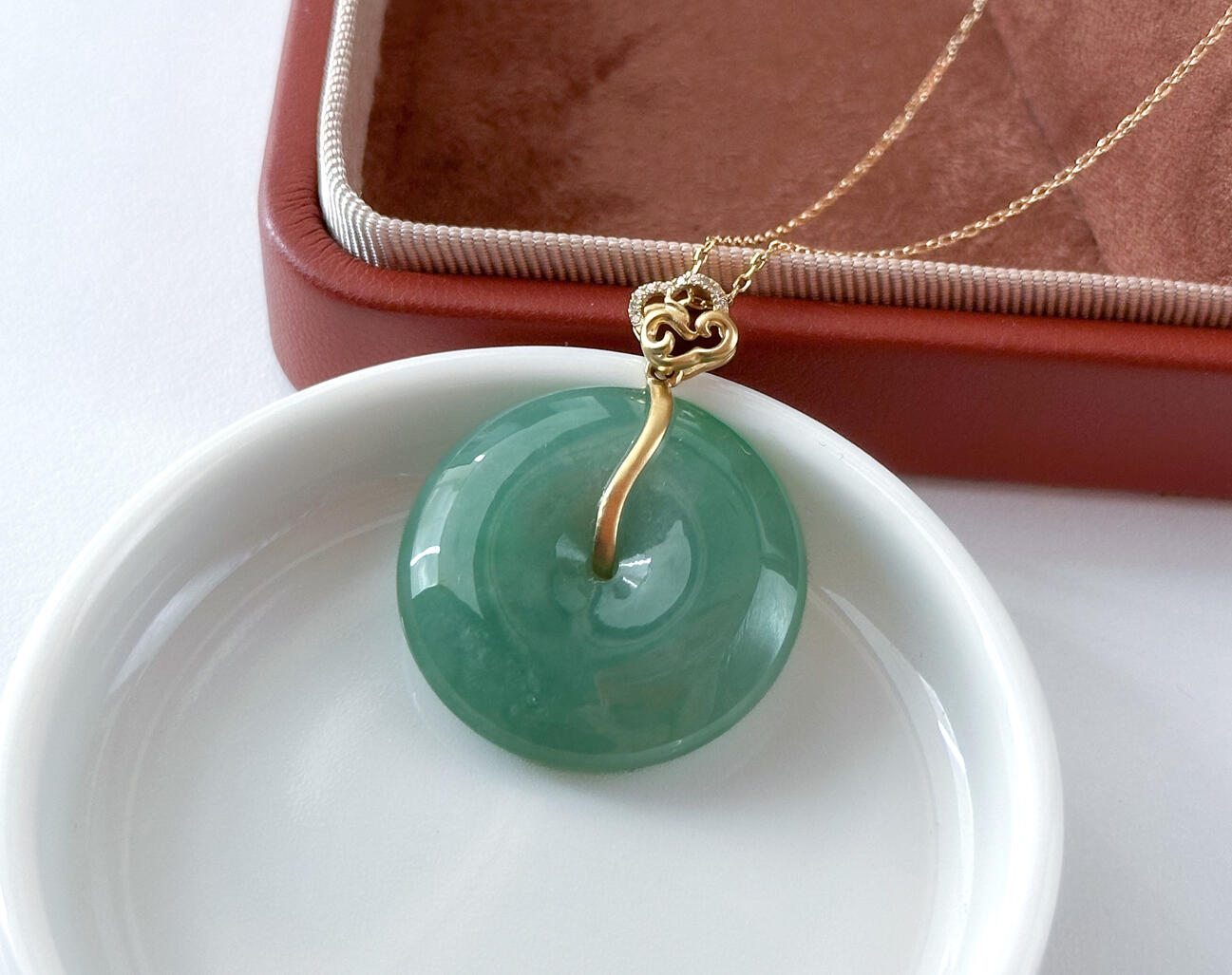 Close Up Detail Green Jadeite Doughnut Pendant Bespoke Gold Cloud Bail Lying on table